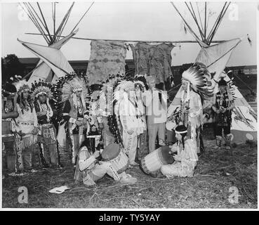 Indische Jamboree. Manheim, Deutschland; Umfang und Inhalt: Chief Willie Linder der Heidelberger Ogalala Stamm rauchen Friedenspfeife. Deutsche und GIs sind als Indianer, mit Tipis, dekoriert mit Fellen und Trommeln in der Bild als gut gekleidet. Ein Beispiel für die erheblichen Deutschen das Interesse an der Geschichte und Kultur des amerikanischen Westens. Stockfoto