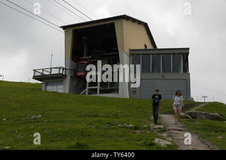 Ein paar Touristen beginnen, der weg von der Seilbahnstation nach dem Reiten der Bergbahn auf den Gipfel der Schweiz Schweizer Ebenalp an einem bewölkten Tag. Stockfoto