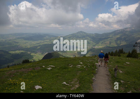 Ein Paar amerikanischer Touristen sind in Ehrfurcht, als sie an einem bewölkten Tag in den Schweizer Alpen auf einem Pfad hoch oben auf der Ebenalp der Schweiz wandern. Stockfoto