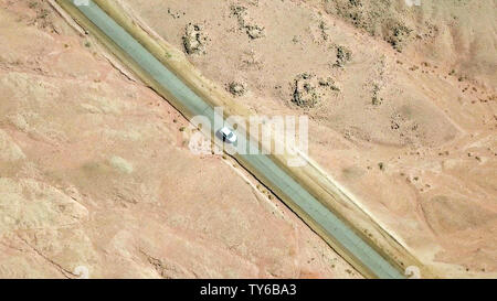 Einziges Auto auf einem alten Wüste Straße, Antenne folgen Bild. Stockfoto