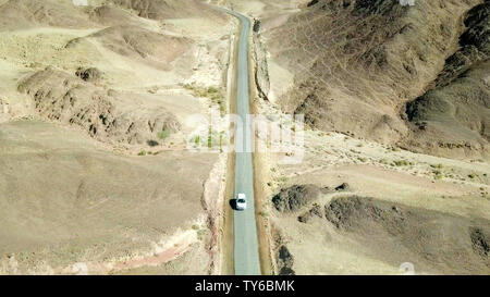 Einziges Auto auf einem alten Wüste Straße, Antenne folgen Bild. Stockfoto