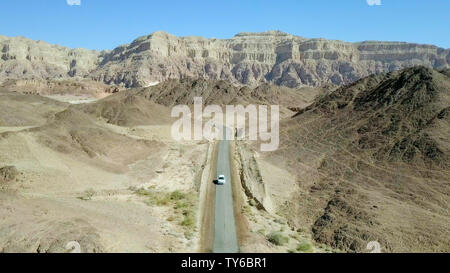 Einziges Auto auf einem alten Wüste Straße, Antenne folgen Bild. Stockfoto