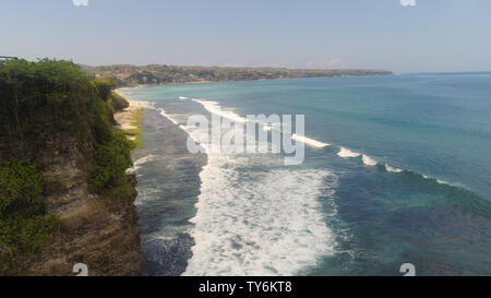 Luftaufnahme felsigen Küste mit Sandstrand. marine Ocean Surf und tropischen Strand türkisblaues Wasser große Wellen brechen am Strand Bali, Indonesien. Travel Concept. Stockfoto