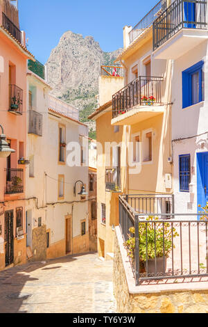 Finestrat, Spanien - 12. Juni 2019: Straße in Finestrat Altstadt mit schönen Häusern und schmalen Berg Puig Campana Hintergrund Stockfoto