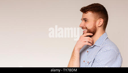 Junge tausendjährigen Mann weg bei copy Space suchen und lächelnd Stockfoto