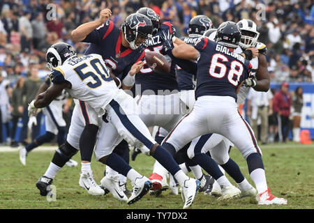 Texans' Quarterback Tom Savage ungeschickte Versuche nach im LA Coliseum in Los Angeles, Kalifornien am 12. November 2017 in Angriff genommen werden von Rams linebacker Samson Ebukam (50). Foto von Jon SooHoo/UPI Stockfoto