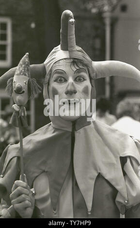 80er Jahre, eine Nahaufnahme eines modernen Jester oder Entertainer in einem Kostüm, die ihre historischen Pendants, England, UK ähneln gekleidet. Im Mittelalter, ein Spaßvogel war ein Schauspieler, der gemeinsamen Folk auf Messen und Märkten unterhalten, während der "hofnarr" Mitglied des königlichen Haushalts, deren Job war der König und seine Gäste in Bankette und Partys zu unterhalten wurde. Narren haben eine lange Geschichte und wurden in vielen von Shakespeares Dramen, einschließlich 'Twelfth Night', wo Feste der Narr ist beschrieben als "klug genug, der Narr" zu spielen. Stockfoto