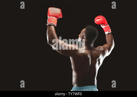 Afrikanische Boxer genießen gewinnen, heben die Hände in Boxhandschuhe Stockfoto