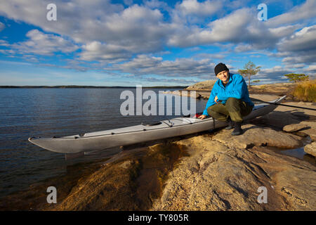 Outdoor Fotograf Øyvind Martinsen mit seinem Kajak in den See Vansjø, Østfold, Norwegen. Vansjø ist ein Teil des Wassers, das System namens Morsavassdraget. Stockfoto