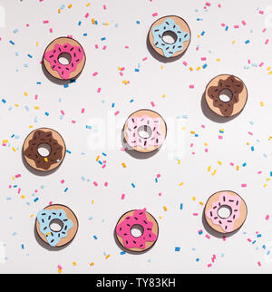 Kreative Hintergrund mit farbigen Donuts auf weißem Hintergrund Stockfoto