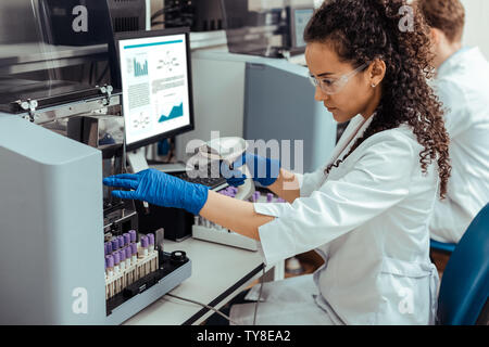 Smart nette Frau im Reagenzglas suchen Stockfoto