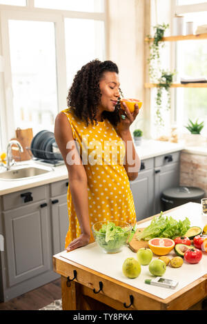 Schwangere Frau riechen eine Halbe Grapefruit. Stockfoto