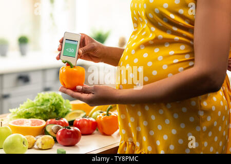 Schwangere Frau messen Nitrate in Paprika. Stockfoto