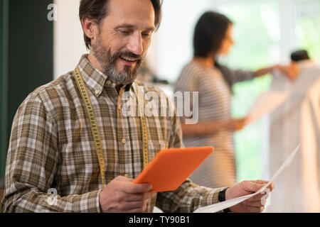 Gesicht - Portrait von Designer tragen Zentimeter und Tablet in der Hand halten Stockfoto