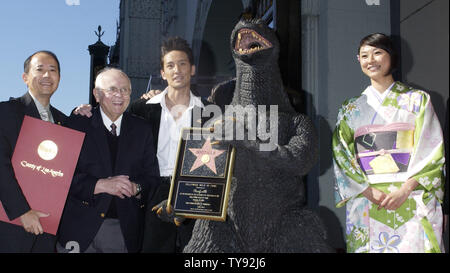 Film 'Godzilla' hält eine Replik Plakette während mit japanischen Schauspielern und Regisseuren während einer Zeremonie ein Stern auf dem Hollywood Walk of Fame erhalten posiert in Hollywood, Kalifornien, 29. November 2004. Von links sind Hersteller Shogo Tomiyama, ehrenamtlicher Bürgermeister von Hollywood Schauspieler Johnny Grant, Masahiro Matsuoka, Godzilla, und Schauspielerin Rei Kiku Kawa. Der Film Symbol feiert sein 50-jähriges Bestehen mit dem Stern als auch die Premiere des Films "Godzilla Final Wars" später am Tag. (UPI Foto/Jim Ruymen) Stockfoto