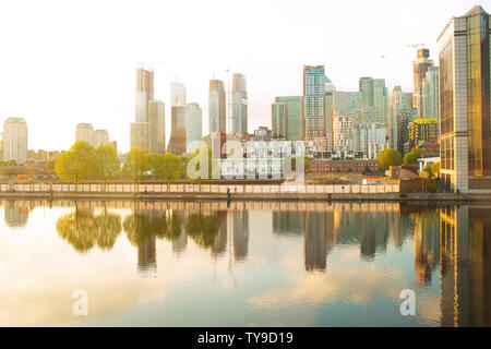 Hohe Geschäftshäuser an den Fluss bei Sonnenuntergang am äußeren Millwall Dock, Isle of Dogs, London, Vereinigtes Königreich, Stockfoto