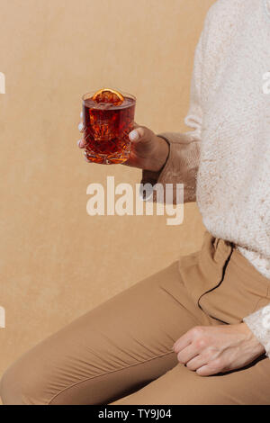Frau und Negroni Cocktail mit Gin, bitter und Wermut. Farbenfroh und trendy. Stockfoto