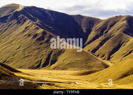 Neuseeland, Südinsel. Wicklung Schmutz oder Schotterpiste durch eine majestätische, karge Landschaft. Foto: © Simon Grosset. Archiv: Bild von digitalisierten Stockfoto