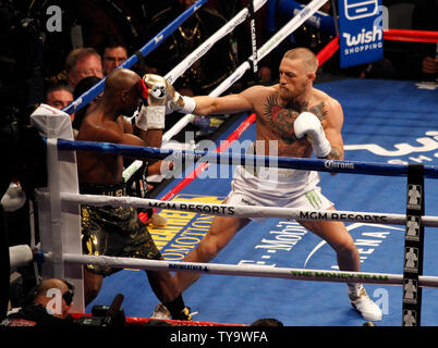 Floyd Mayweather Jr. (L) verteidigt sich gegen Conor McGregor während ihrer super-welterweight bout bei der T-Mobile Arena in Las Vegas, Nevada am 26. August 2017. Mayweather durch TKO in der zehnten Runde gewonnen. Foto von James Atoa/UPI Stockfoto