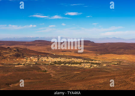 Blick über ein Dorf in Marokko mit schneebedeckten Berge im Hintergrund Stockfoto
