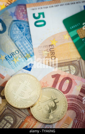 Golden bitcoins mit Euro-Banknoten und Kreditkarte im Hintergrund, neue Währung, Finanzen Konzept Stockfoto