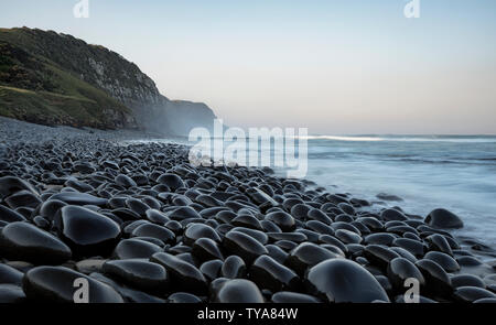 Die unglaublichen schwarzen Kieselstrand von Weißen Ton, erinnert an die Zeit der pelagischen winter Wanderungen und Seefahrt Geschichten. Coffee Bay, Eastern Cape Stockfoto