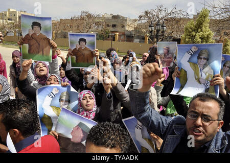 Anhänger der Libyian leader Muammar Gaddafi halten Sie ein Bild der libysche Führer, wie sie Parolen während einer pro Gesang - Regierung Rallye in Tripolis am 19. April 2011. UPI/Ahmad gegangen. Stockfoto