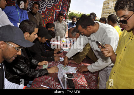 Anhänger der Libyian leader Muammar Gaddafi Stempel, Ihre Fingerabdrücke auf eine Petition, die fordert "Libyen" in einem Zelt bei einem pro-government Rally in Tripolis am 19. April 2011. UPI/Ahmad gegangen. Stockfoto