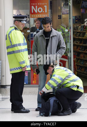 Die Metropolitan Police Officers stop Suche Mitglieder der Öffentlichkeit hält an Londons Victoria Station nach Sicherheitsstufen nach den jüngsten terroristischen Anschlägen auf das Londoner Verkehrssystem am 28. Juli 2005 auf das maximale Niveau angehoben wurden. (UPI Foto/Hugo Philpott) Stockfoto