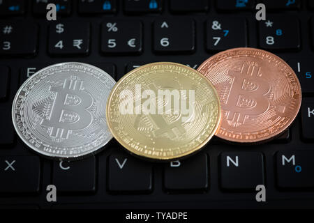 Drei bitcoins auf schwarz Tastatur von Notebook Stockfoto