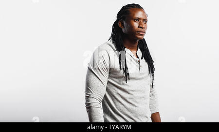 Muskulöse afrikanische Mann mit Dreadlocks auf weißem Hintergrund. Afrikanischer Mann weg schauen. Stockfoto