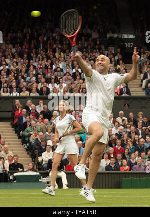 Amerikanischer Tennisstar Andre Agassi volleys die Kugel während ein gemischtes Doppel mit Frau Steffi Graf gegen Großbritannien Tim Henman und Kim Clijsters. Das Match war spielte das erste Spiel auf der neue Wimbledon Centre Court zu feiern mit dem Dach komplett am Sonntag, den 17. Mai 2009 geschlossen. (UPI Foto/Hugo Philpott) Stockfoto