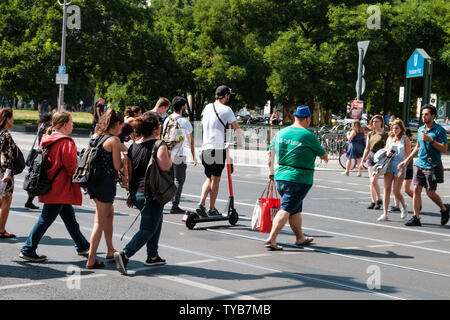 Berlin, Deutschland - Juni, 2019: Fußgänger und Mann auf Elektroroller, e-Scooter Escooter oder Kreuzung Straße Stockfoto