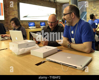 Ein Kunde spricht, ein Apple Mitarbeiter im Covent Garden in London auf den Tag der Einführung des neuen Apple iPad 3 Am 16. März 2012. Käufer in 10 Ländern rund um die Welt werden immer die Gelegenheit, die neue Apple Tablet mit einige Leute in der Warteschlange für die über 70 Stunden für die Eröffnung zu erwerben. UPI/Hugo Philpott Stockfoto