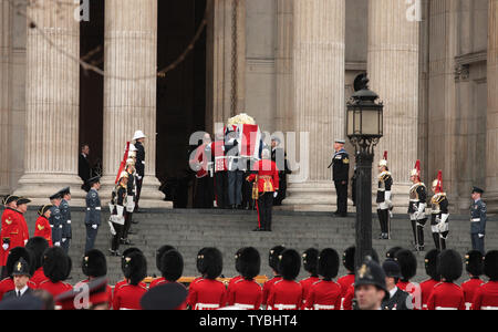 Mitglieder der bewaffneten Kräfte tragen den Sarg der ehemaligen Premierministerin Margaret Thatcher in der St. Paul's Cathedral, wo 2000 geladene Gäste und die Staats- und Regierungschefs für ihr Begräbnis am 17. April 2013 versammelt haben. Der Sarg von Baroness Thatcher war entlang der Route, die von Tausenden von wellwishers mit nur ein paar hundert gegen sie protestieren angefeuert. UPI/Hugo Philpott. Stockfoto