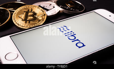 26. Juni 2019, Wuhan China: Waage die Facebook cryptocurrency Logo auf Handy und echten Münzen von anderen Crypto wie Bitcoin daneben Stockfoto