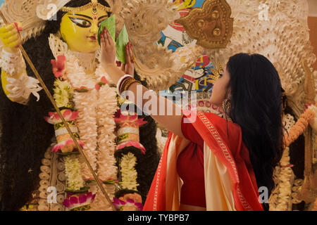 Bengali verheiratete Frau Anbetung Göttin Durga mit betal Blatt Stockfoto