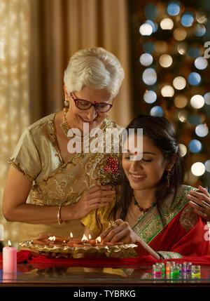 Die Schwiegertochter Verzieren des Hauses bei der Schwiegermutter anlässlich von diwali Stockfoto