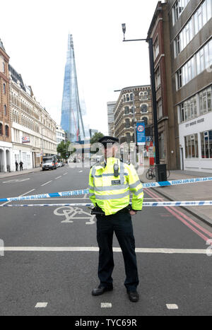 Ein Polizist bewacht eine Cordon in der Nähe der London Bridge in London am 4. Juni 2017. Letzte Nacht drei Terroristen sieben Menschen getoetet und verletzte 48 Menschen nach der Fahrt einen Van auf Fußgänger und begeht einen rasenden Messer atack im nahegelegenen Borough Market. Polizei Forensik Offiziere weiterhin für Beweise im Bereich und in großen Teilen von London zu sehen bleiben gesperrt. UPI Foto/Hugo Philpott Stockfoto