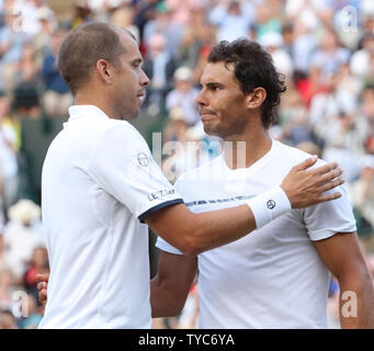 Der Spanier Rafael Nadal ist in der Niederlage durch den Luxemburger Gilles Muller am Tag Sieben der 2017 Wimbledon Championships getröstet, London Am 10. Juli 2017. Foto von Hugo Philpott/UPI. Stockfoto