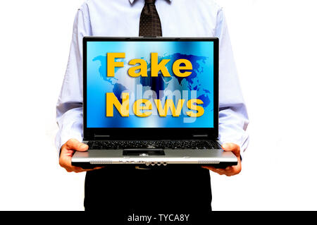 Mann hält einen Laptop mit Worten gefälschte Nachrichten auf dem Bildschirm Stockfoto