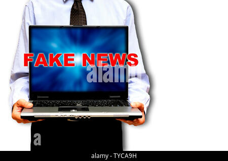 Mann hält einen Laptop mit Worten gefälschte Nachrichten auf dem Bildschirm Stockfoto
