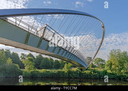 Die Millennium Bridge in New York. Ein modern gestaltetes steel Suspension Bridge mit einem gebogenen Bogen und Kabel. Ein blauer Himmel mit Wolken ist oben. Stockfoto