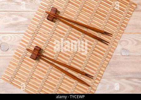 Zwei Sätze von Sushi mit Stäbchen auf Holz Bambus Hintergrund, Ansicht von oben. Stockfoto