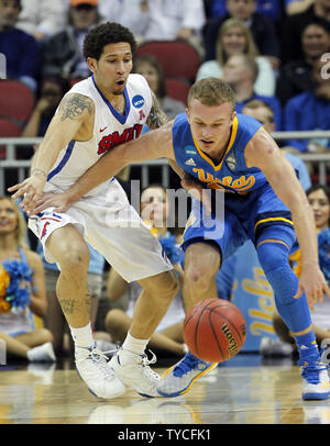 UCLA Bruins' Bryce Alford (20) kämpft für die lose Kugel mit der SMU Mustangs 'Nic Moore (11) während der zweiten Hälfte des Spiel in der zweiten Runde Spiel der NCAA Division I 2015 Men's Basketball Meisterschaft an der KFC Yum! Zentrum in Louisville, Kentucky, 19. März 2015. Foto von John Sommers II/UPI Stockfoto