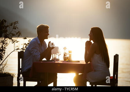 Paar Teilen romantische Abendessen bei Sonnenuntergangs auf tropischen resort Stockfoto