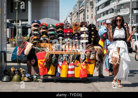 Berlin, Deutschland - Juni, 2019: Souvenir Anbieter verkaufen Objekte im Kalten Krieg auf der Straße im Landmark Checkpoint Charlie in Berlin, Deutschland Stockfoto