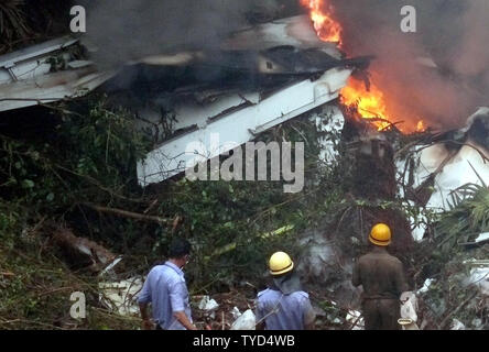 Feuerwehrmänner Begießen der Air India Express Ebene, nachdem der Start- und Landebahn hinausgeschossen und Bajpe Airport in Mangalore, Indien stürzte am 22. Mai 2010. Der 166 Passagiere und Besatzungsmitglieder an Bord, nur 8 überlebt. UPI Stockfoto