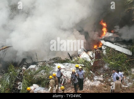 Feuerwehrmänner Begießen der Air India Express Ebene, nachdem der Start- und Landebahn hinausgeschossen und Bajpe Airport in Mangalore, Indien stürzte am 22. Mai 2010. Der 166 Passagiere und Besatzungsmitglieder an Bord, nur 8 überlebt. UPI Stockfoto