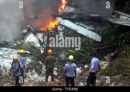 Feuerwehrmänner Begießen der Air India Express Ebene, nachdem der Start- und Landebahn hinausgeschossen und Bajpe Airport in Mangalore, Indien stürzte am 22. Mai 2010. Der 166 Passagiere und Besatzungsmitglieder an Bord, nur 8 überlebt. UPI Stockfoto